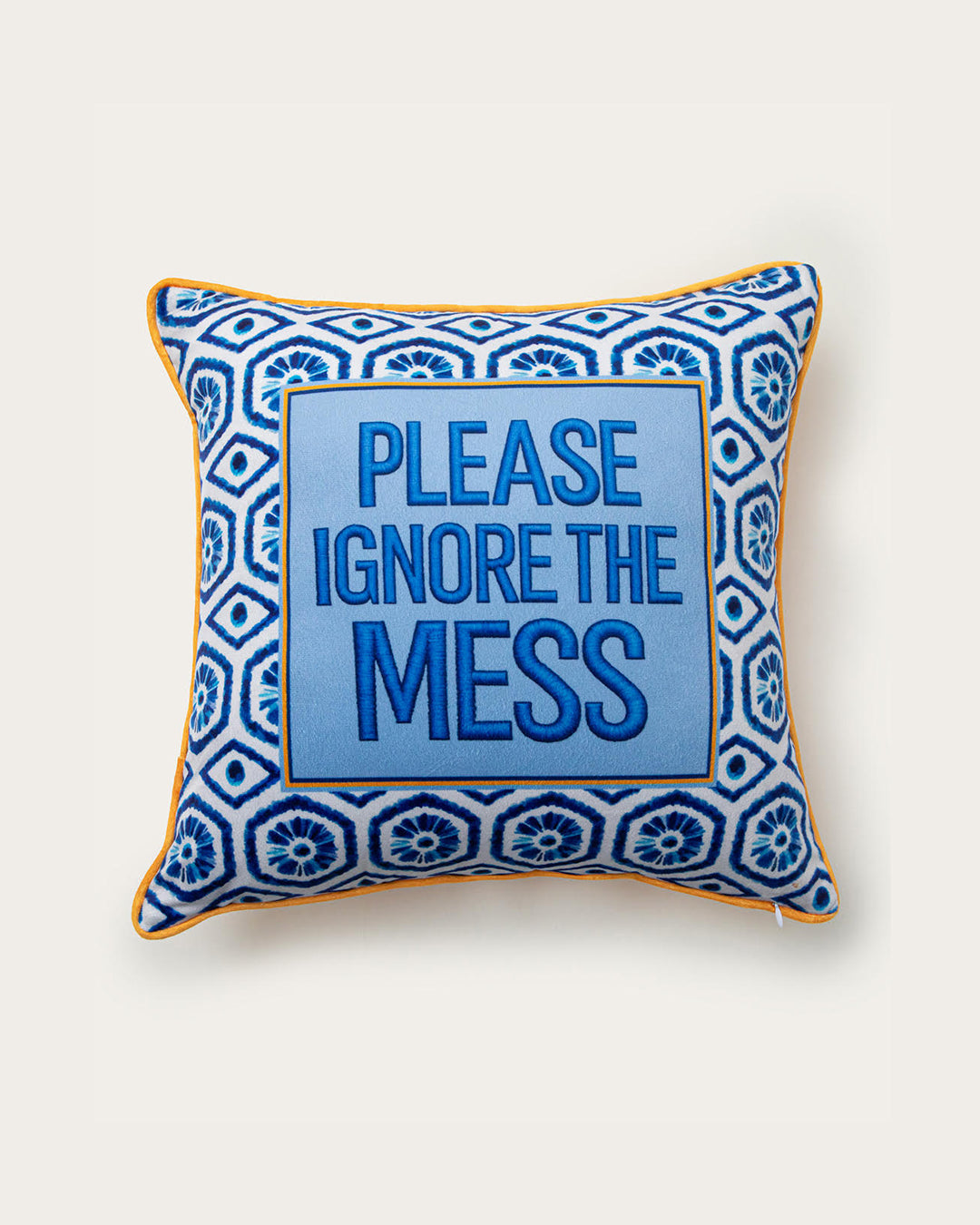 Decorative pillow with blue and white pattern and text 'Please Ignore the Mess' on a white background